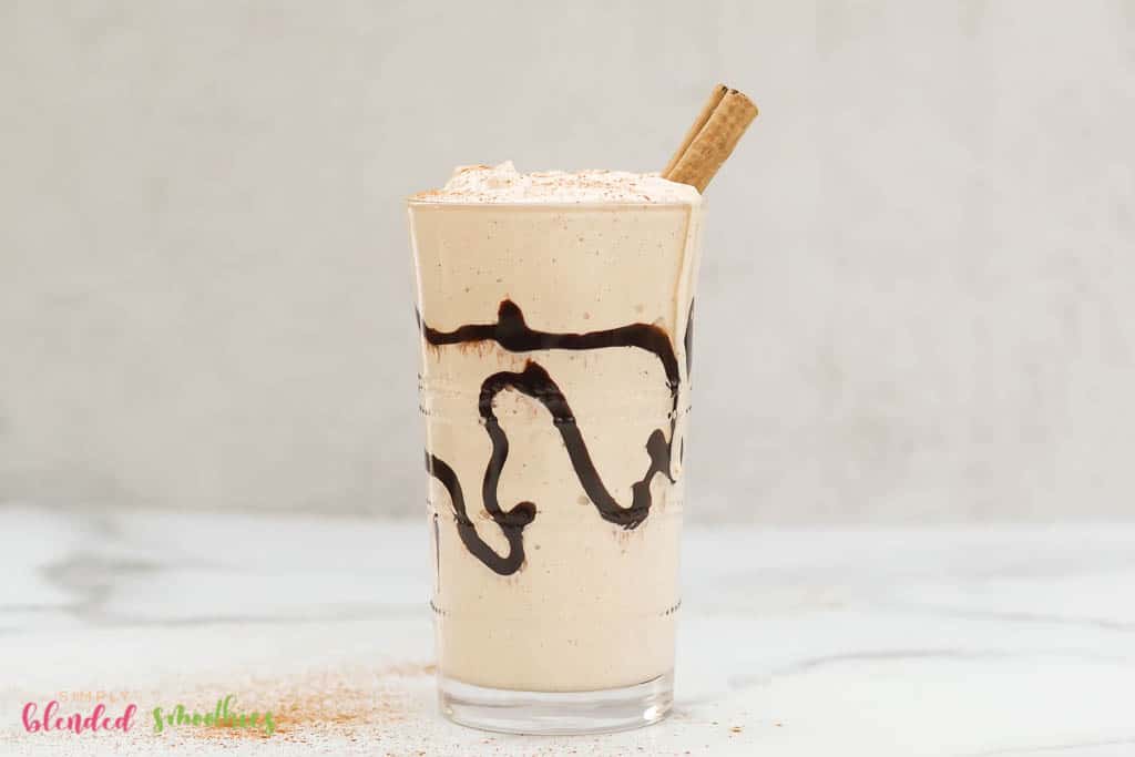Eggnog Milkshake With A Cinnamon Stick In It And Chocolate Swirl