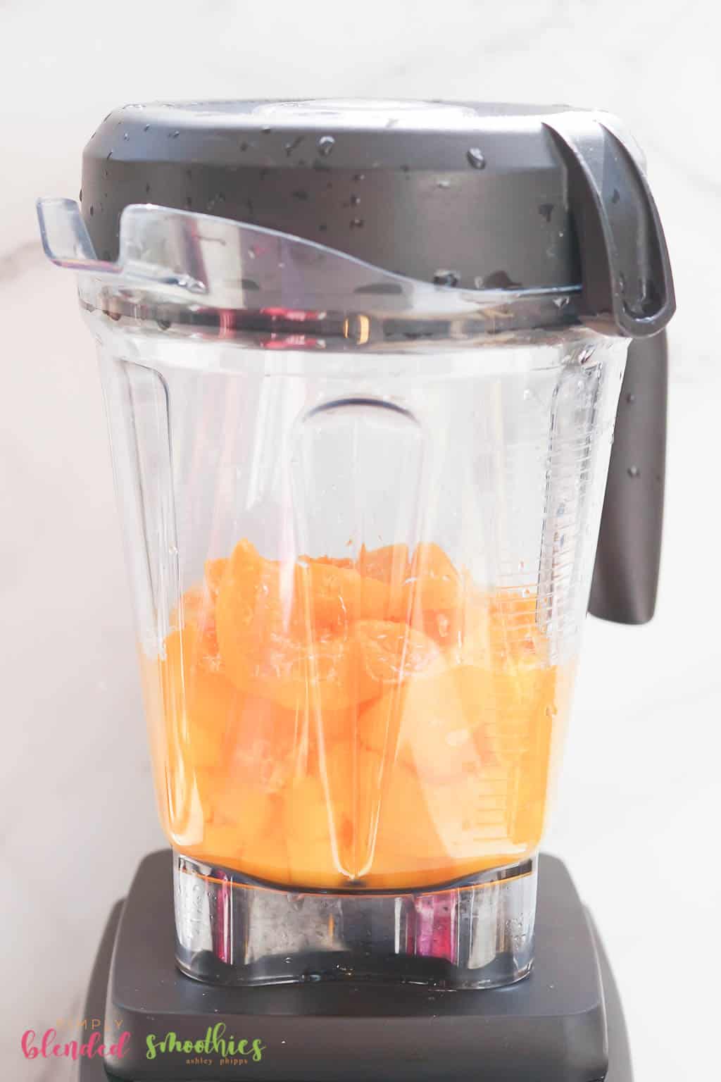 Looking At The Side Of A Blender With Mangos And Peaches In It
