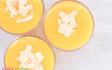 mango peach smoothie with coconut flakes looking from the top down